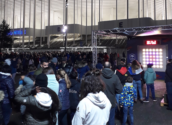 Groupe de spectateurs devant le mur digital à l'entrée du stade Matmut Atlantique